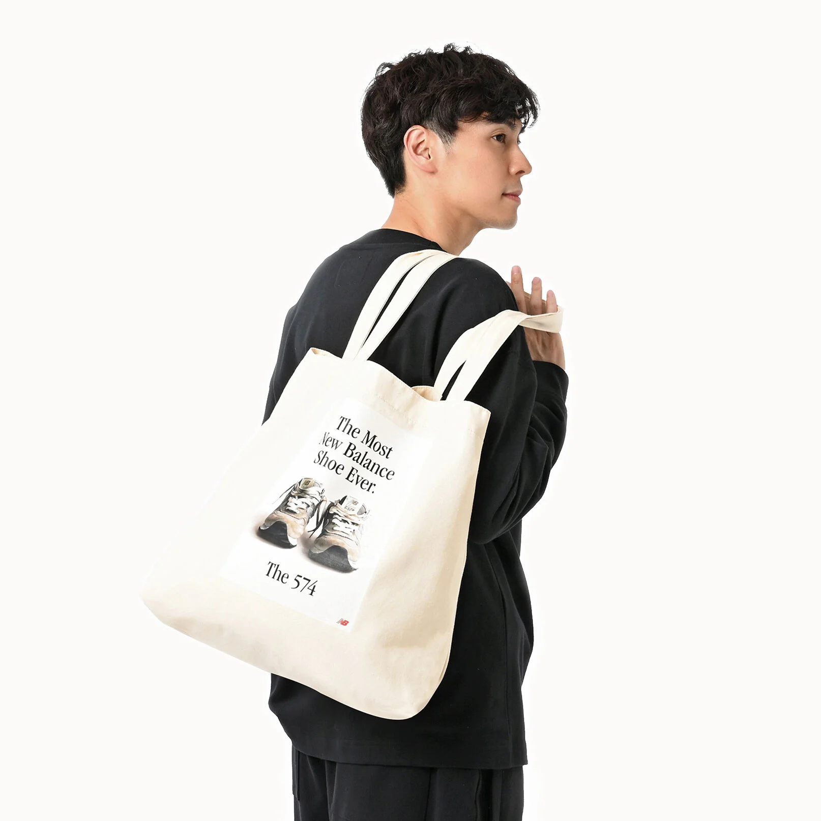 Man holding New Balance tote bag. 
